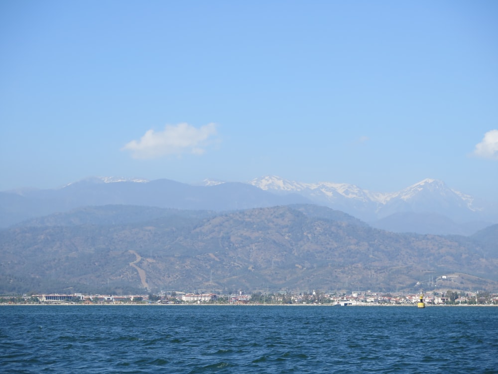 body of water near mountain during daytime