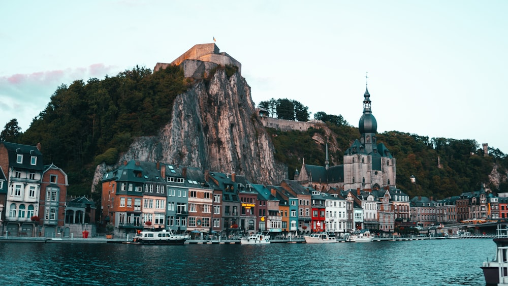 houses on mountain beside body of water during daytime