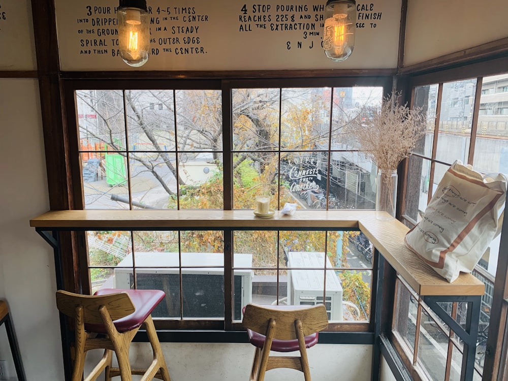 brown wooden table near glass window