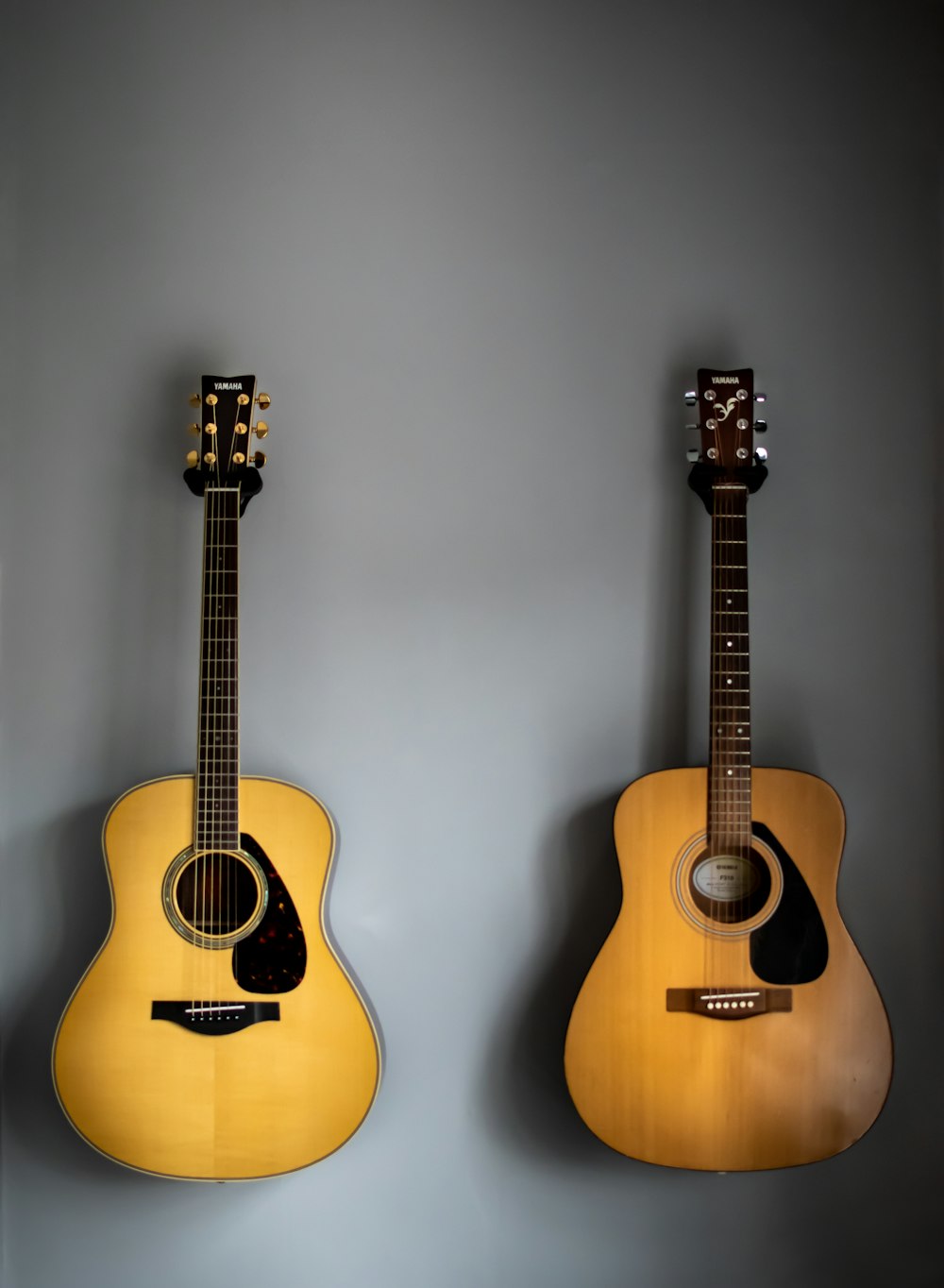 brown acoustic guitar on white wall
