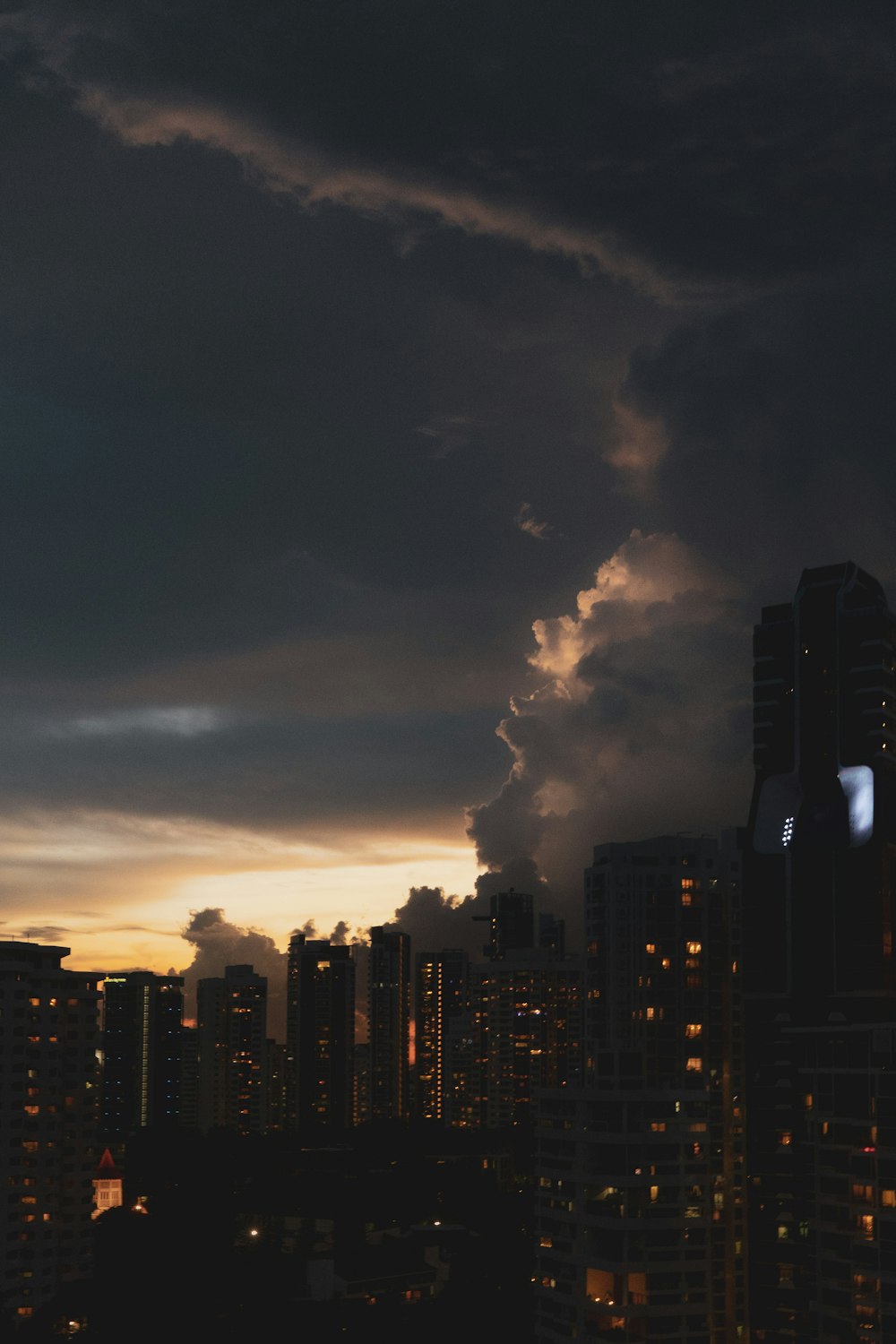 Horizonte de la ciudad bajo el cielo nublado durante la noche
