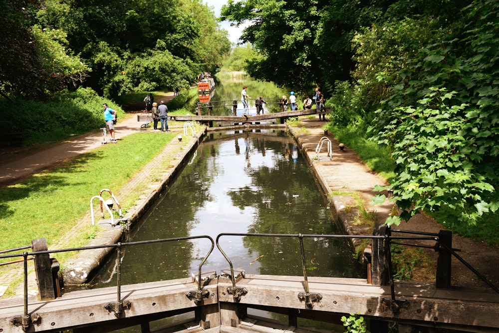 people walking on wooden bridge over river during daytime