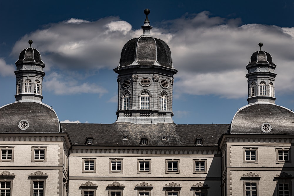 white and black concrete building under white clouds during daytime