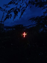 A glowing cross illuminated against a serene evening sky, representing hope and connection.