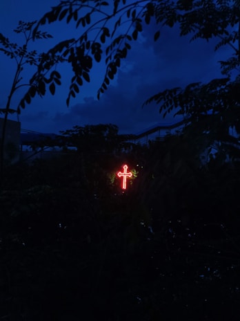 A glowing cross illuminated against a serene evening sky, representing hope and connection.