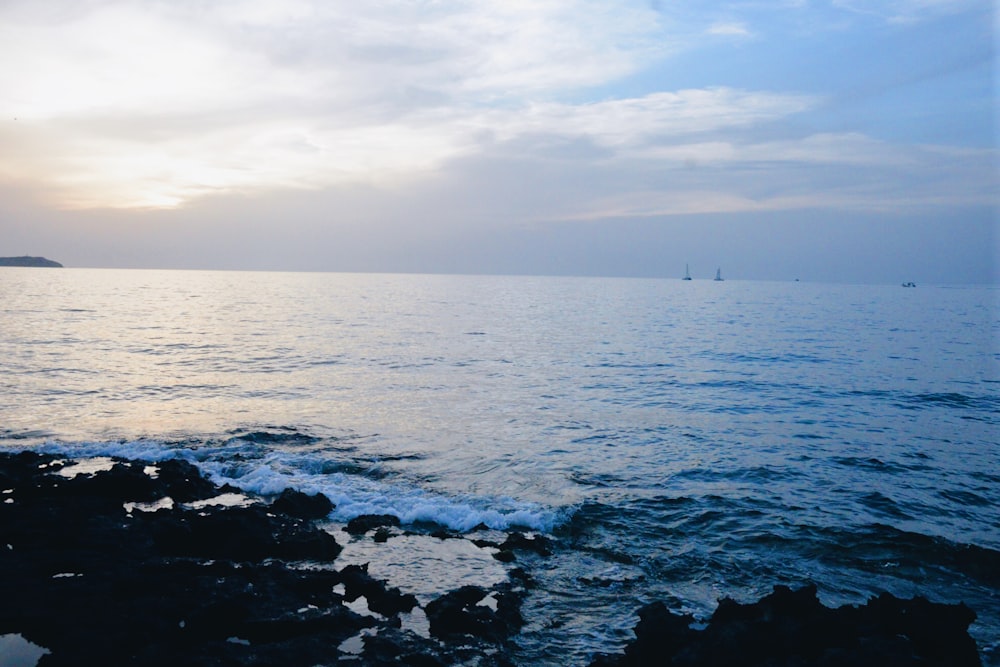 body of water under cloudy sky during daytime