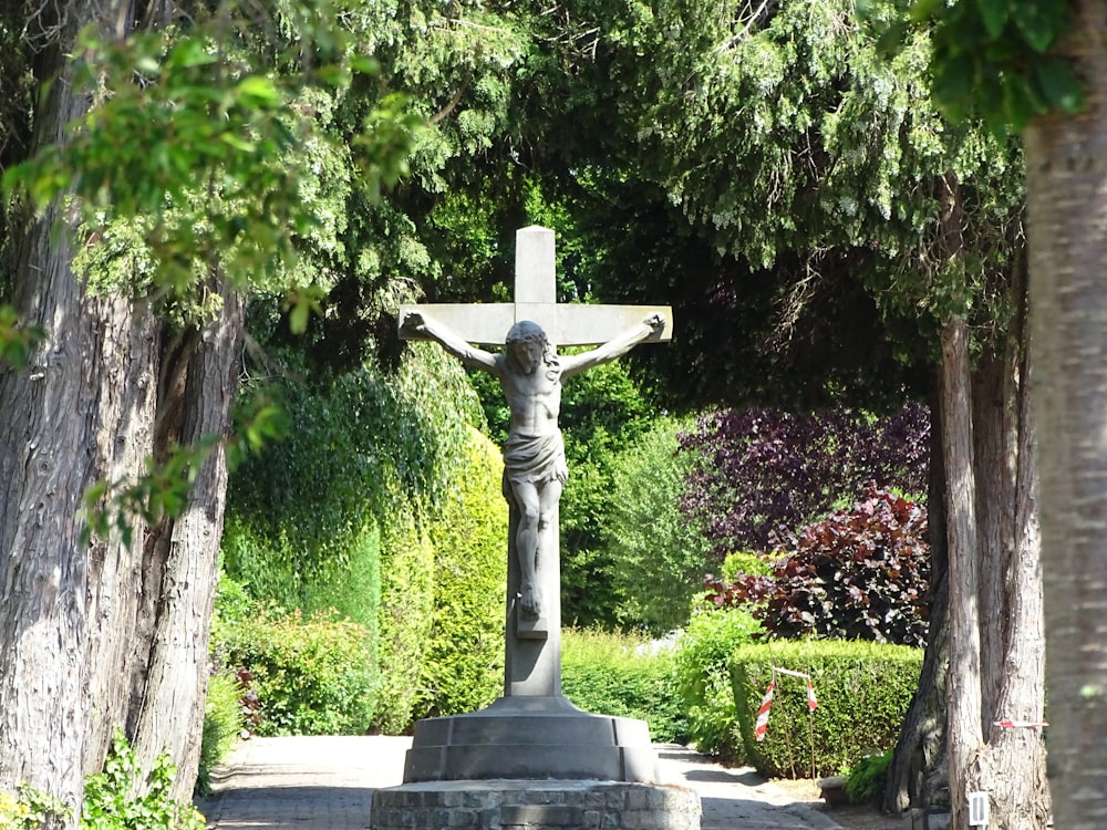 gray concrete statue near green trees during daytime