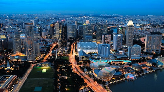 city with high rise buildings during night time in Raffles Place Singapore