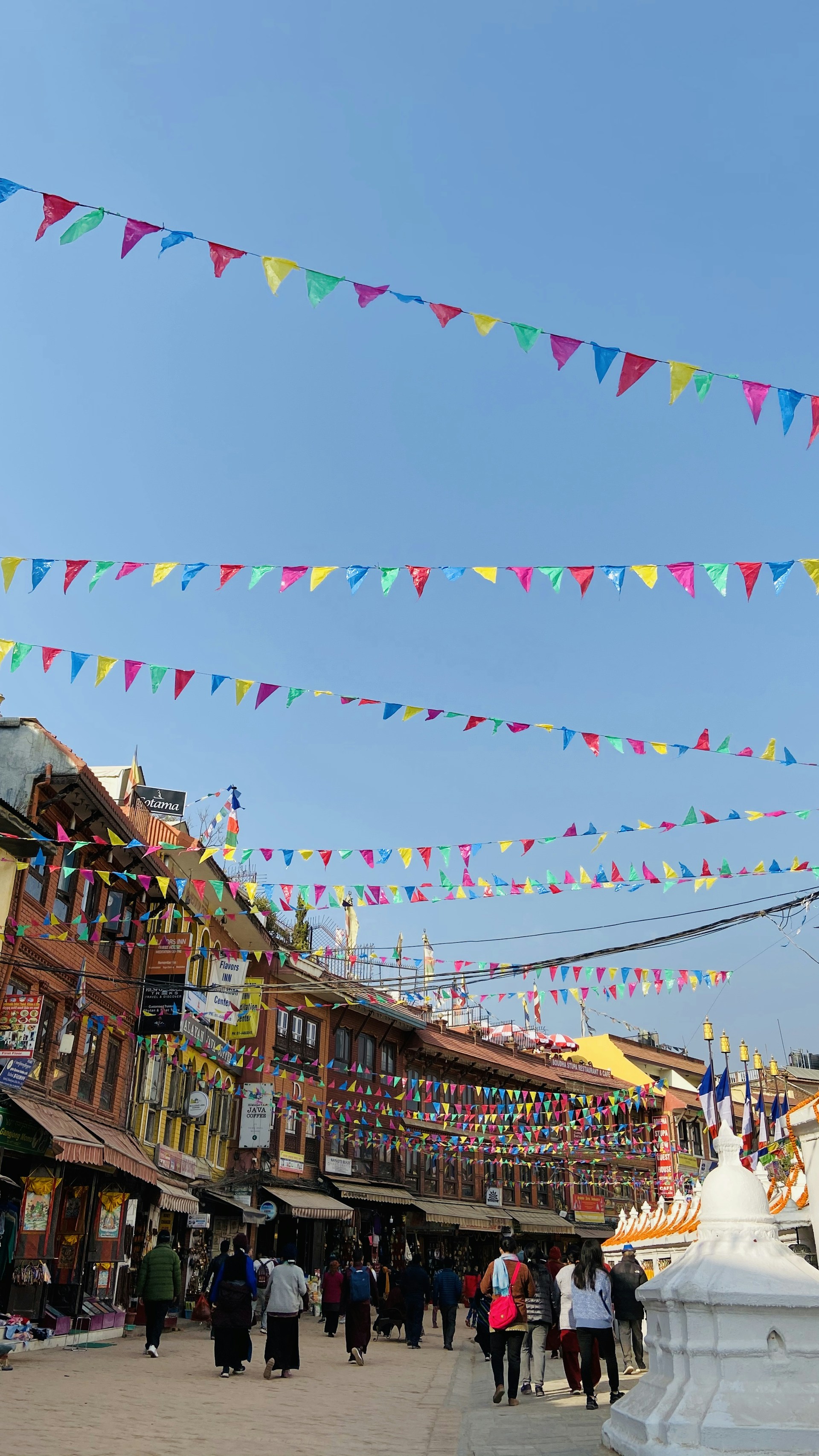 A vibrant street scene in Agartala with locals going about their day under a bright sky.