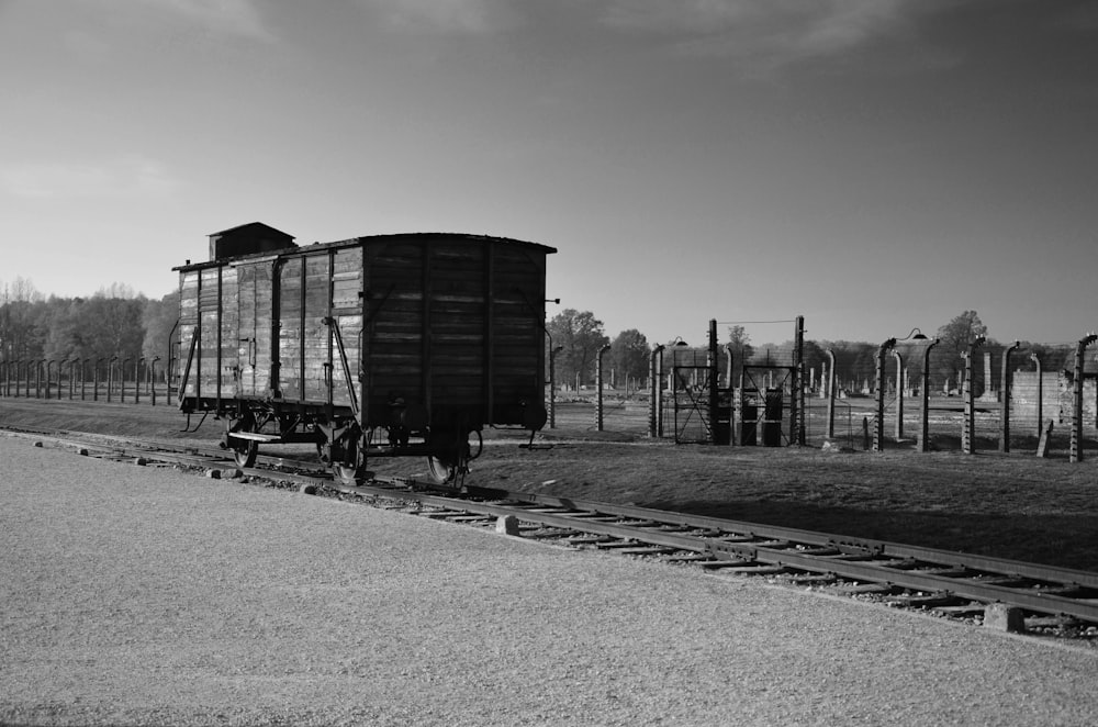foto in scala di grigi del treno sulla strada ferroviaria