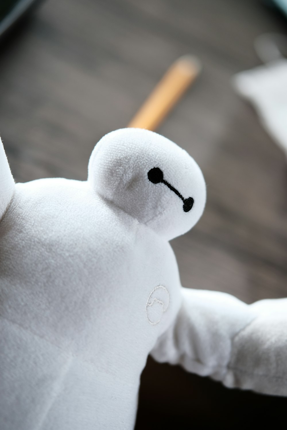 white bear plush toy holding pencil