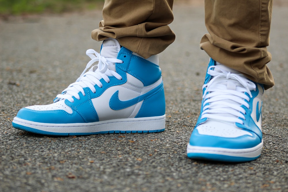 person in brown pants wearing blue nike air jordan 1 shoes