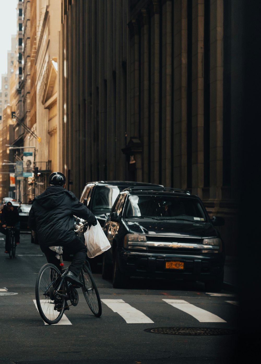 man in black jacket riding bicycle on road during daytime