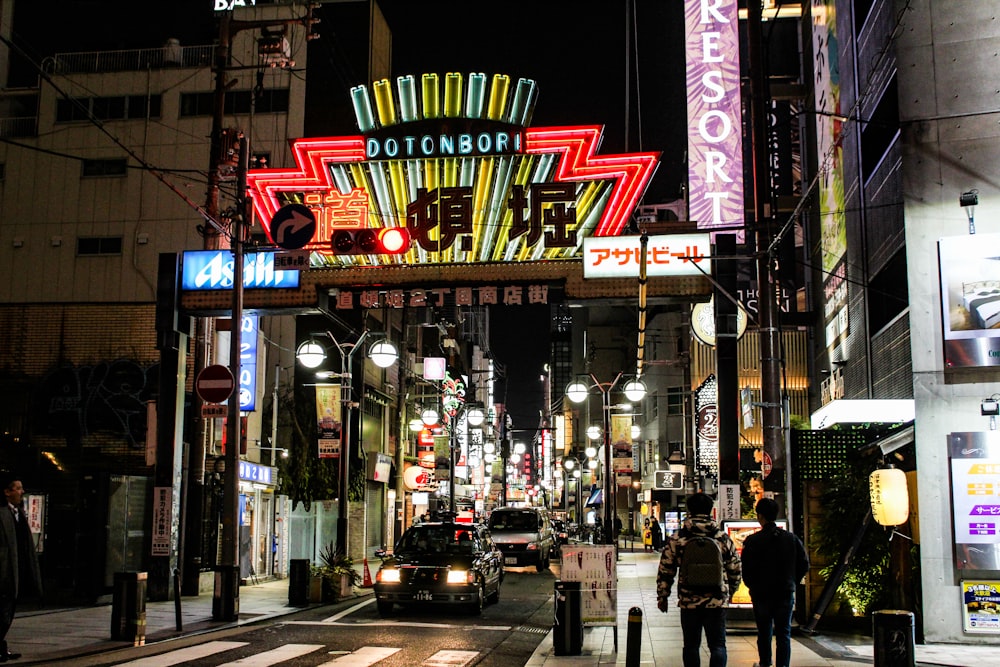 people walking on sidewalk near city buildings during night time