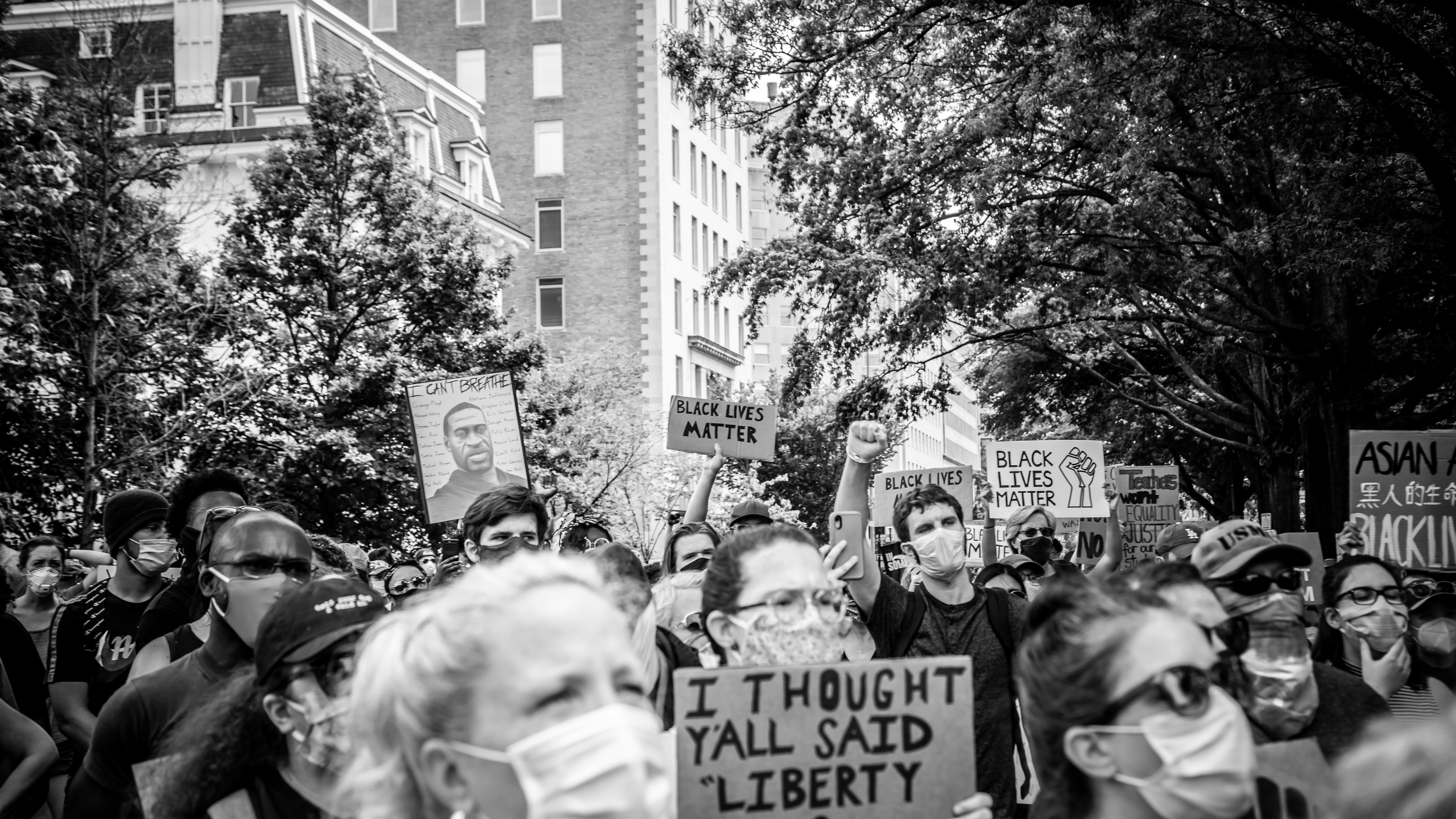 grayscale photo of people walking on street white house teams background