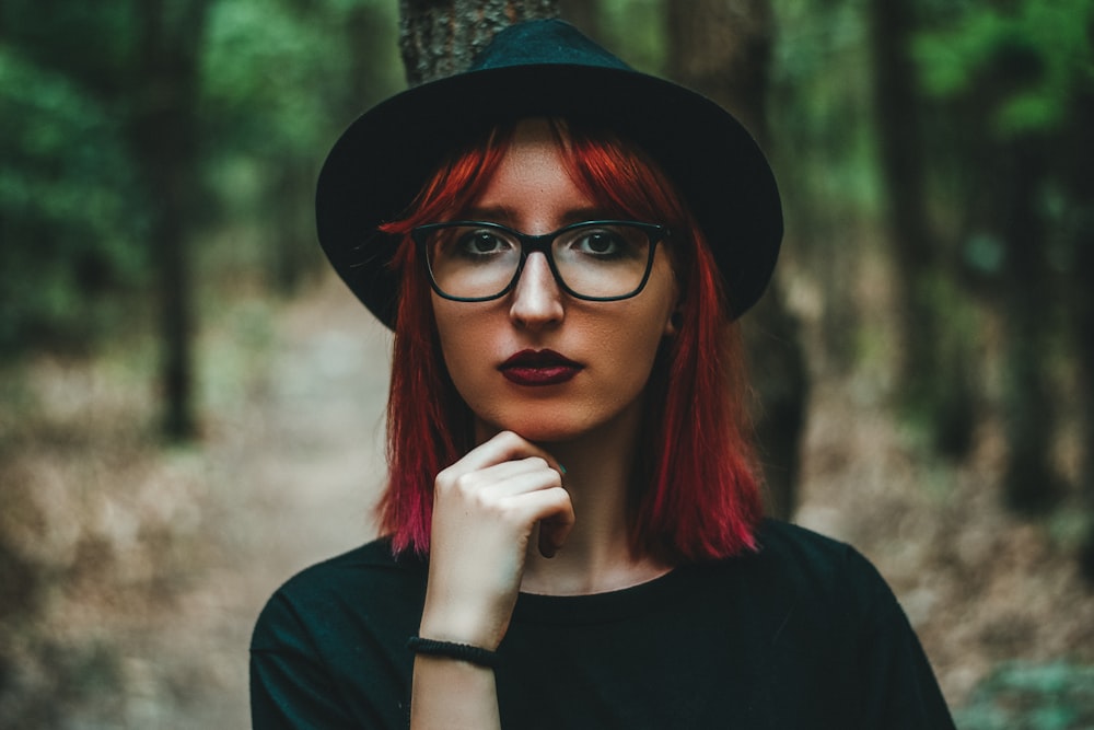 woman in black crew neck shirt wearing black framed eyeglasses and black hat