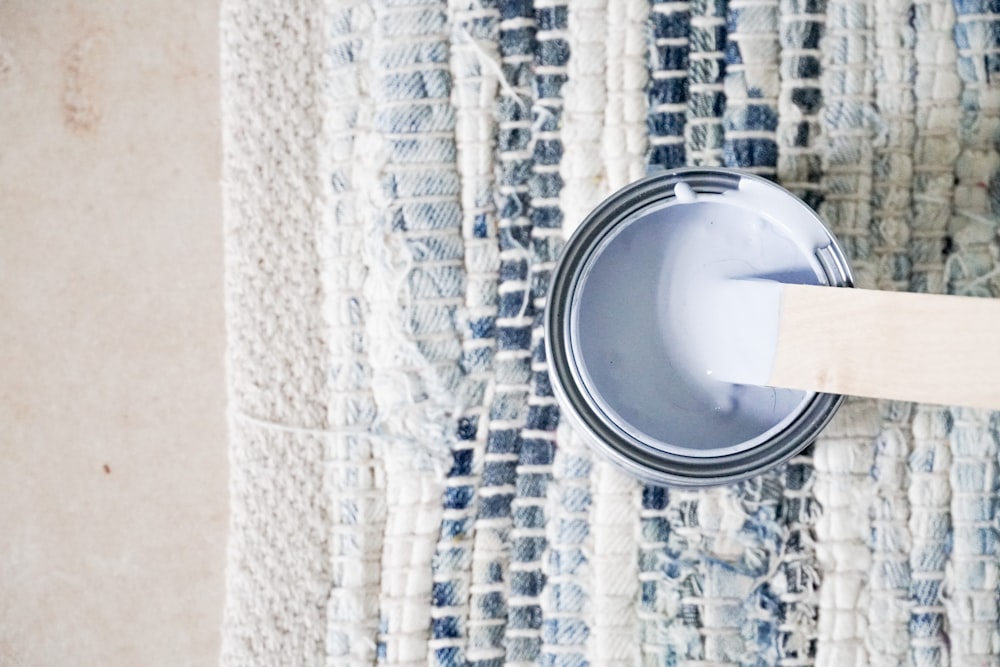 silver round can on white textile