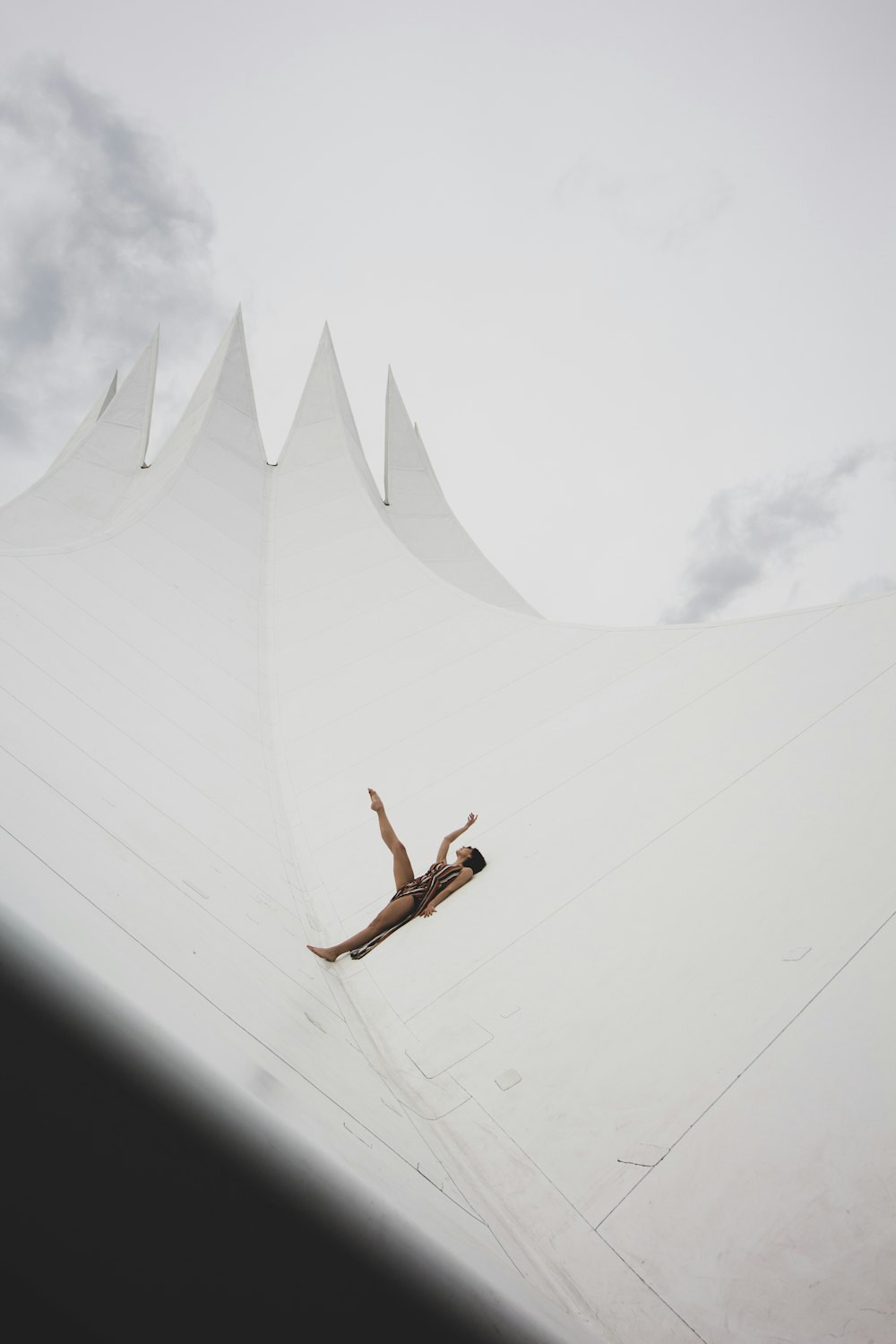 man in black shorts jumping on white concrete wall during daytime