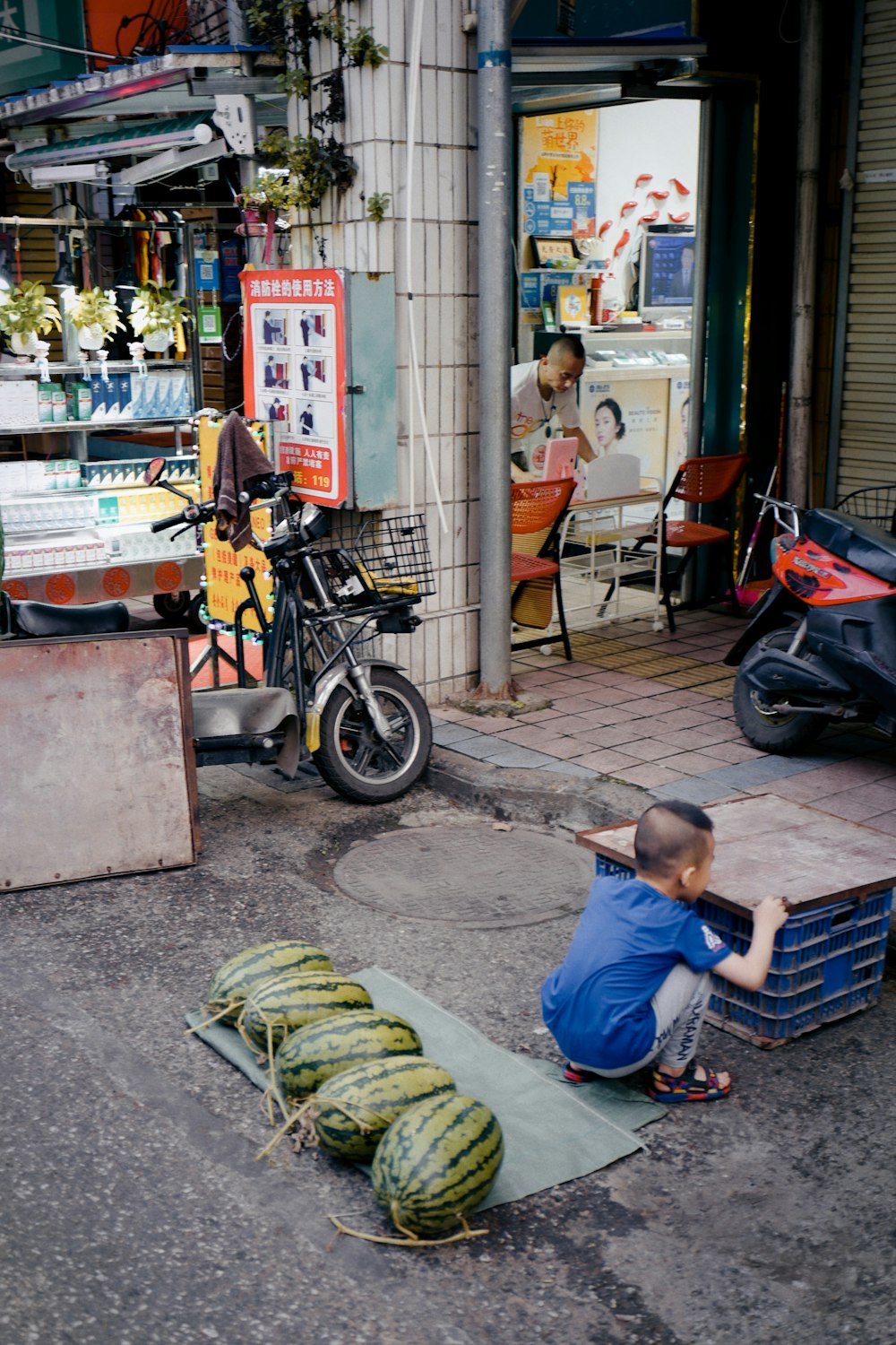 boy in blue t-shirt sitting on the floor