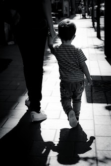 woman in black and white stripe shirt and black pants walking on sidewalk
