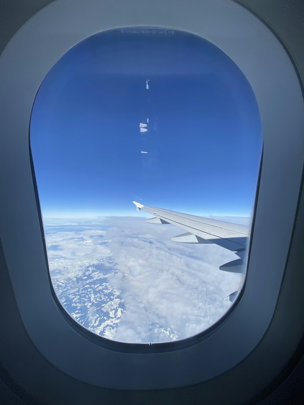airplane window view of white clouds and blue sky during daytime
