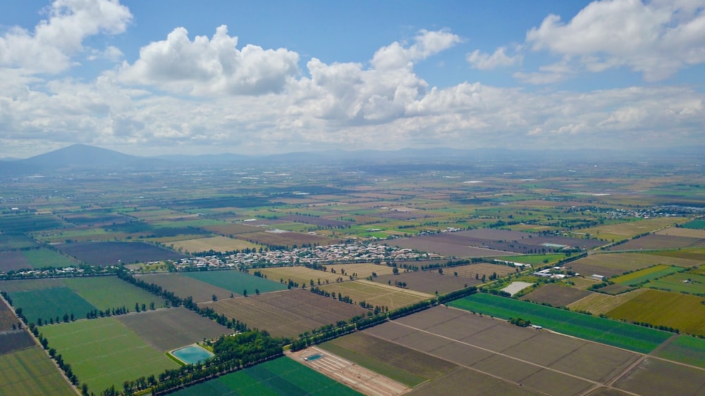 vista aérea do campo verde sob o céu nublado durante o dia
