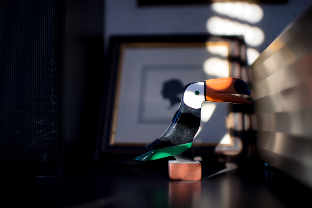 black white and orange bird figurine