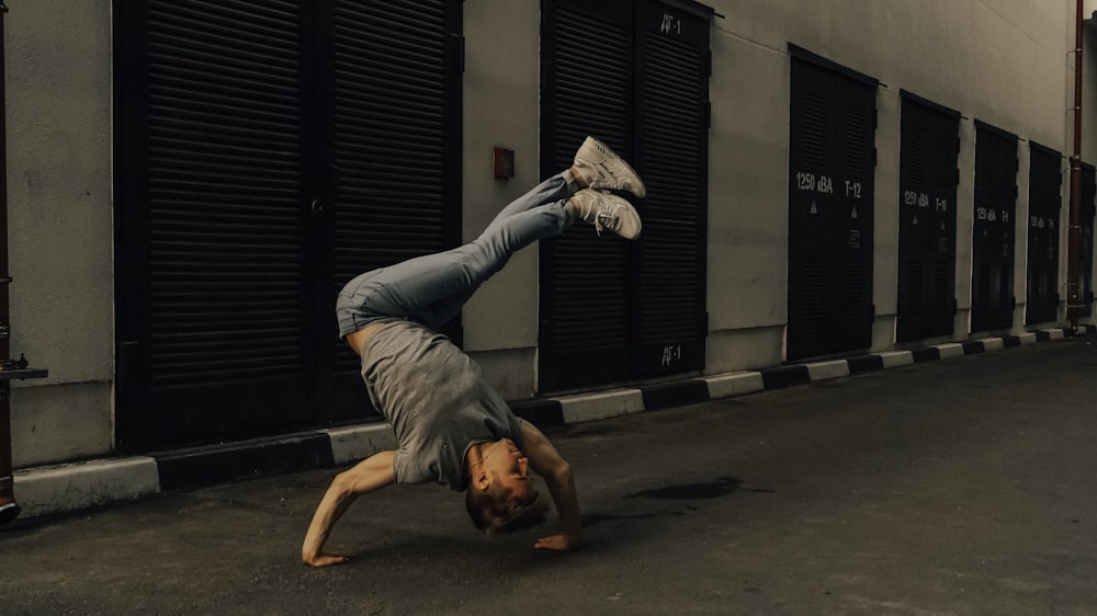 man in gray t-shirt and gray pants doing push up