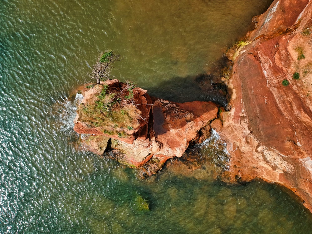 brown rock formation on body of water during daytime