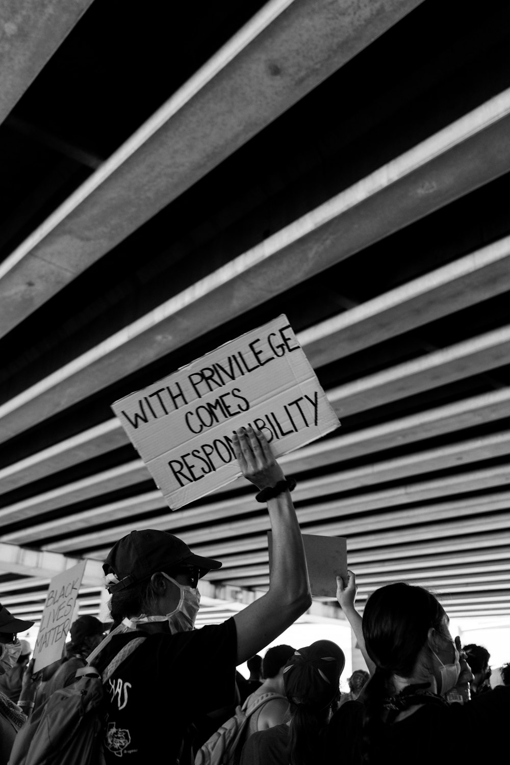 grayscale photo of woman holding sign
