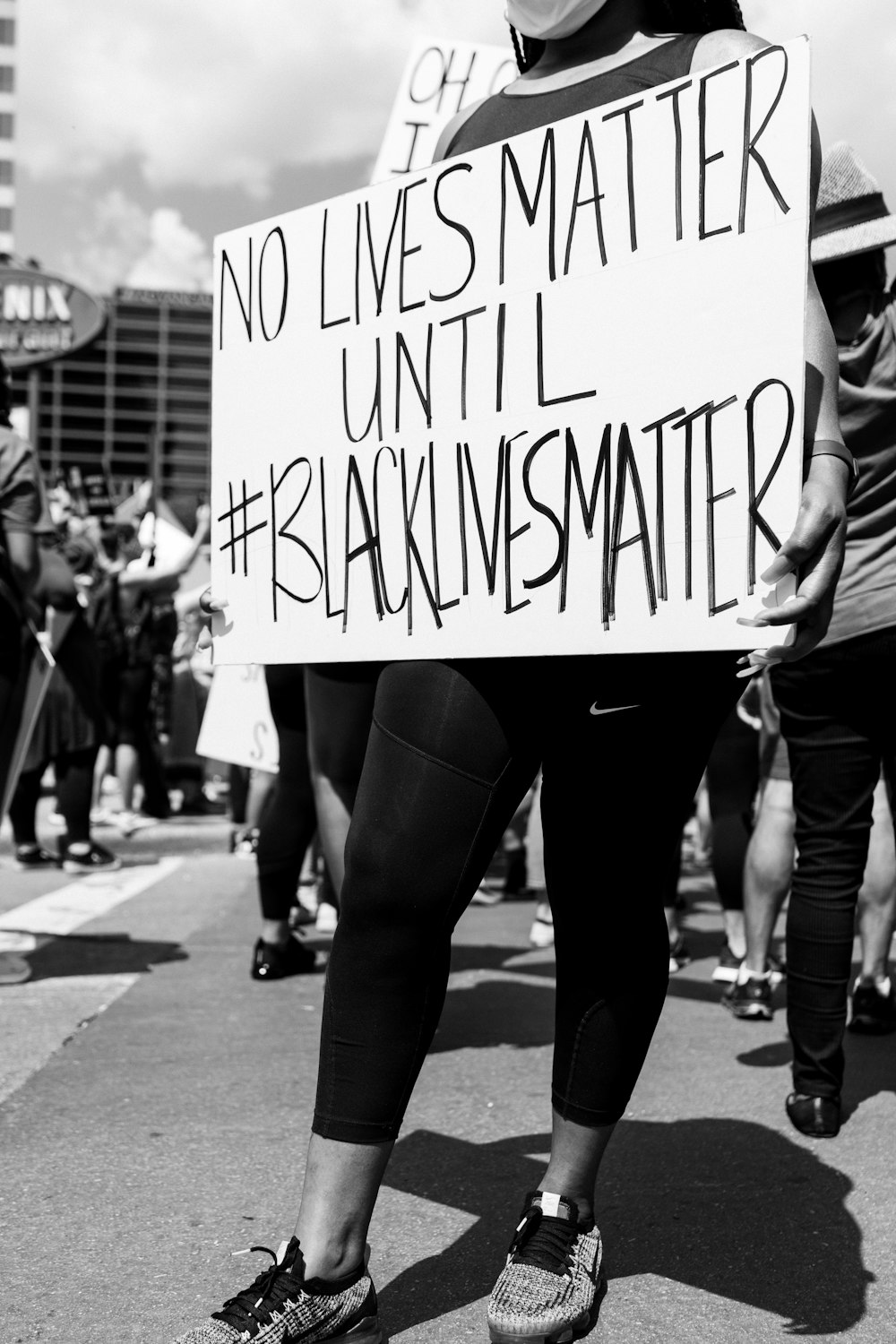 grayscale photo of woman holding i love you print board