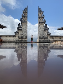 woman in red shirt standing on gray concrete building during daytime