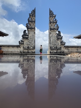 woman in red shirt standing on gray concrete building during daytime