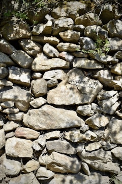 Close-up of a traditional dry stone wall blending into a natural Catalan landscape.