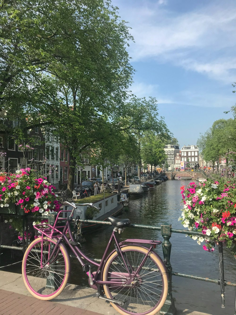 red city bike parked beside river during daytime