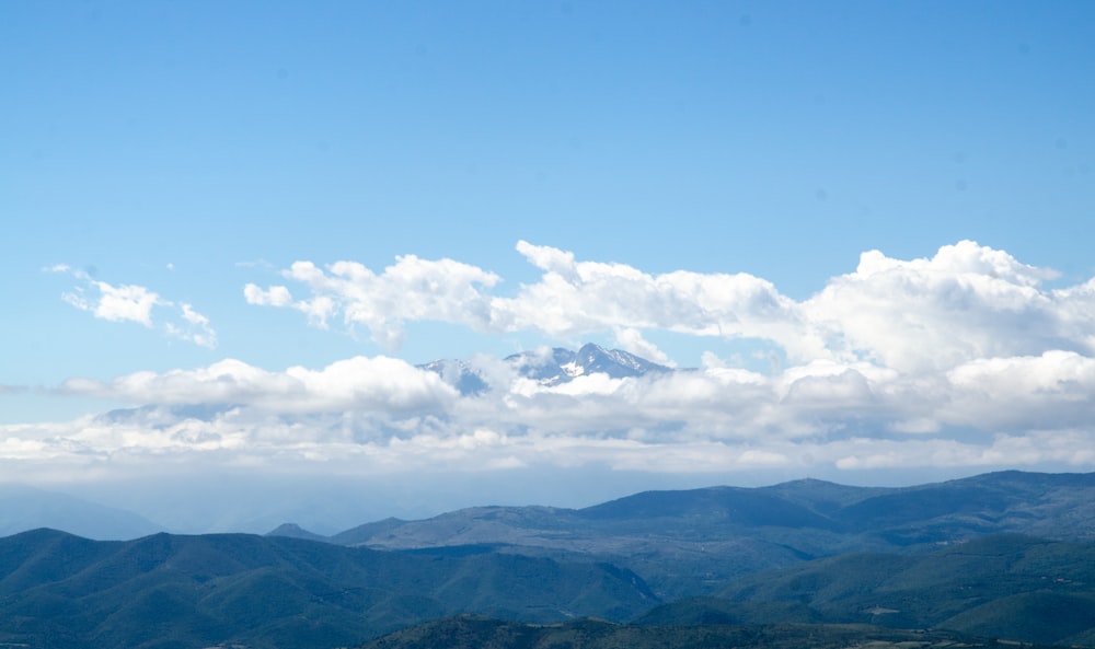 green mountains under white clouds and blue sky during daytime