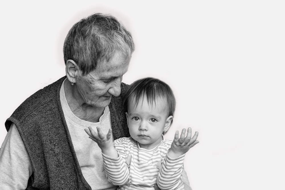 Foto en escala de grises de un hombre que lleva a un niño