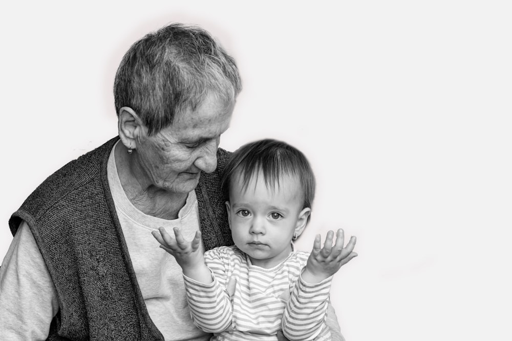 Foto in scala di grigi di un uomo che porta il bambino