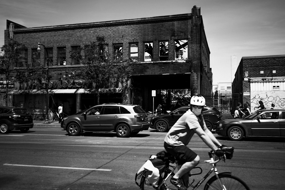 grayscale photo of man riding on motorcycle