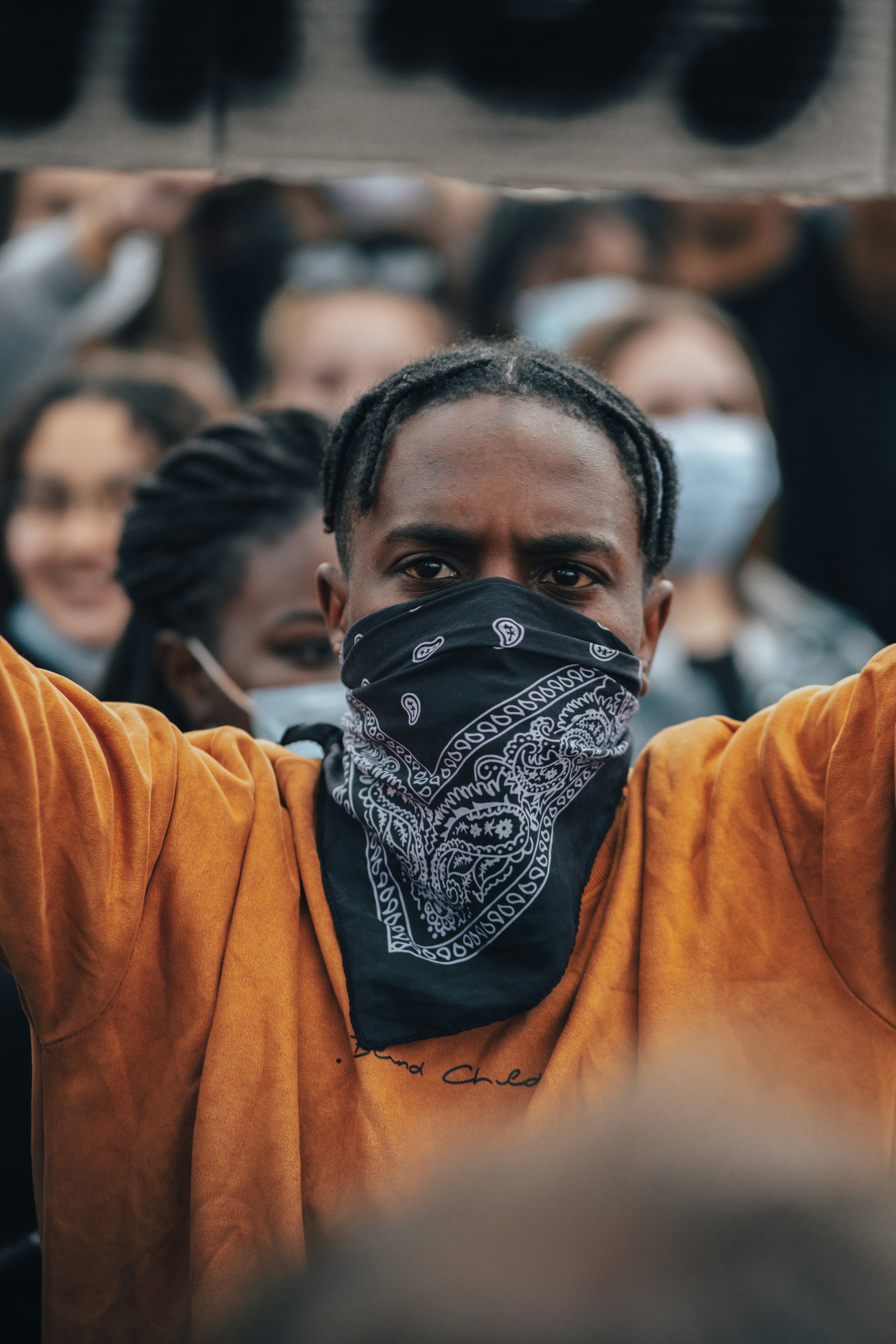 man in orange long sleeve shirt with black and white mask