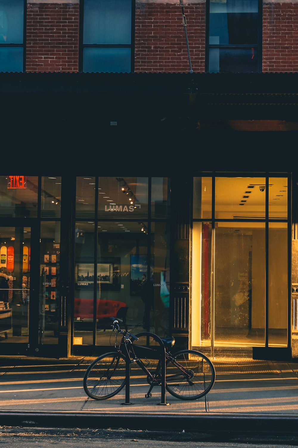 black bicycle parked beside store during night time