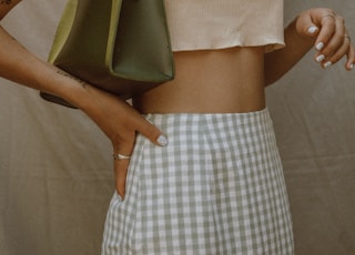 woman in white sleeveless top and white and black plaid skirt