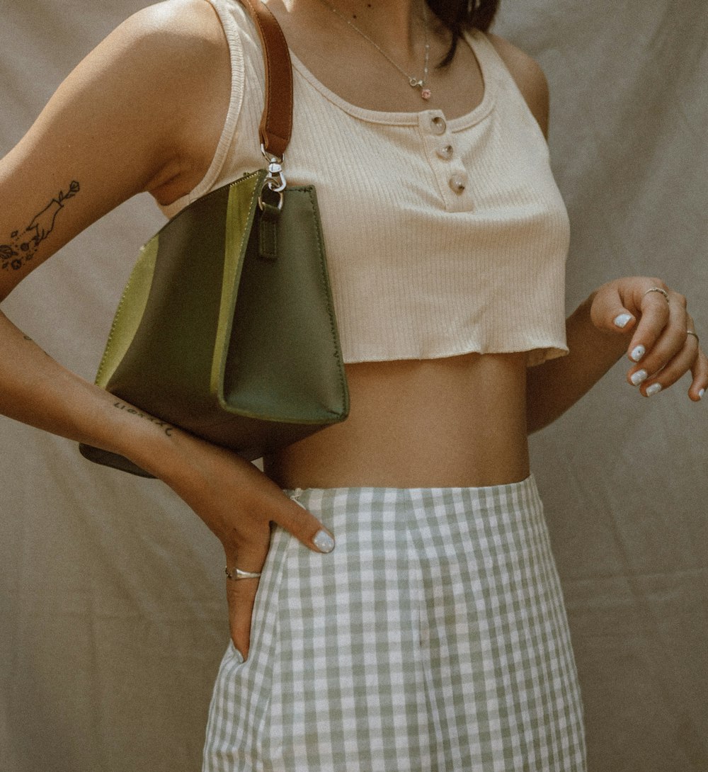 woman in white sleeveless top and white and black plaid skirt