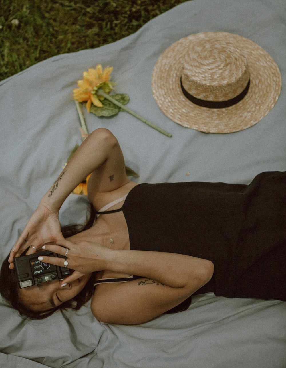 woman in black tank top lying on white textile