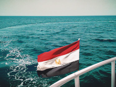 A vibrant embroidered boat flag fluttering in the breeze on a sunny day.