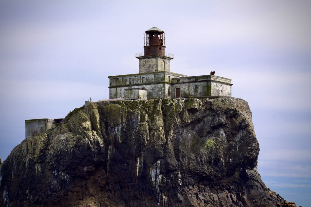 white and brown concrete building on top of gray rock mountain