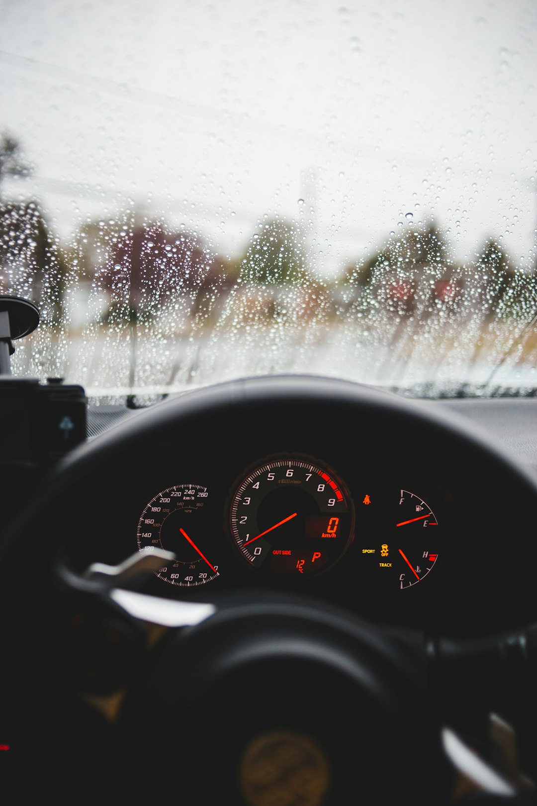 black car steering wheel during rain