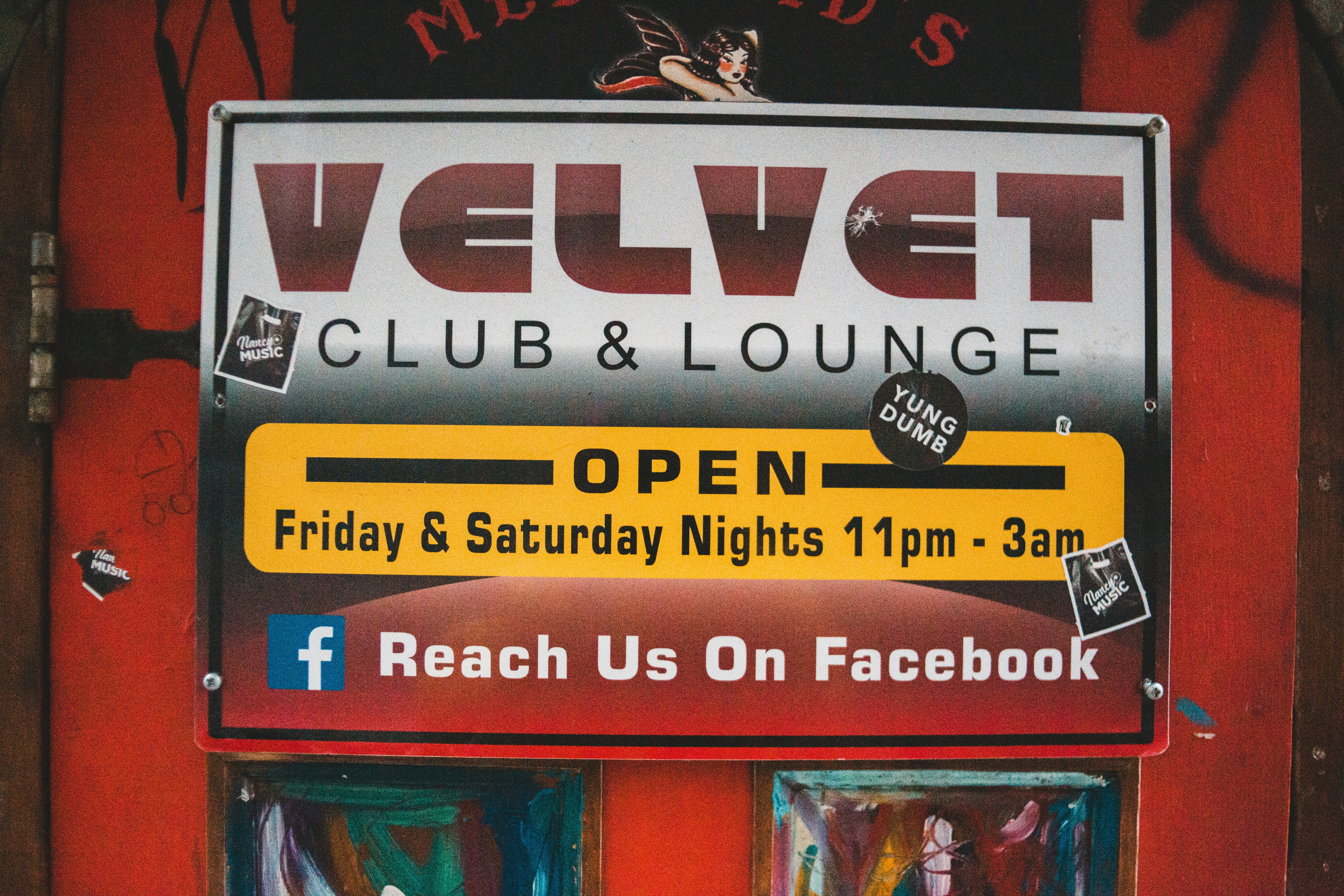 a sign for velvet club and lounge on the side of a building