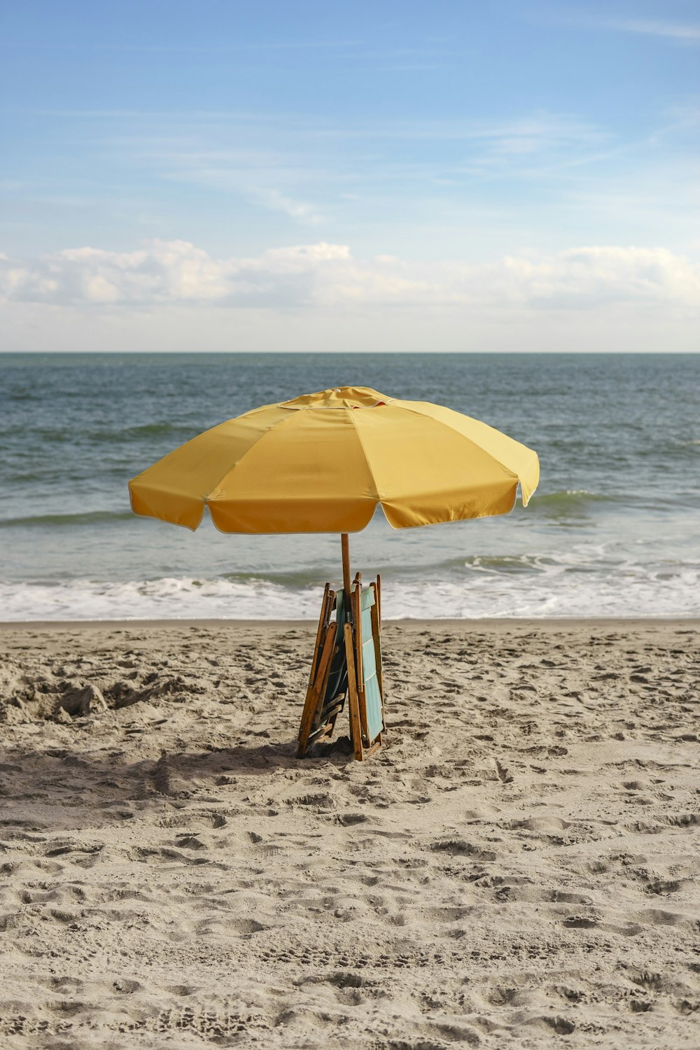 ombrellone giallo sulla spiaggia durante il giorno