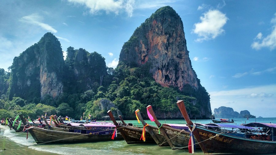 Wooden longtail boat near a mountain in Krabi